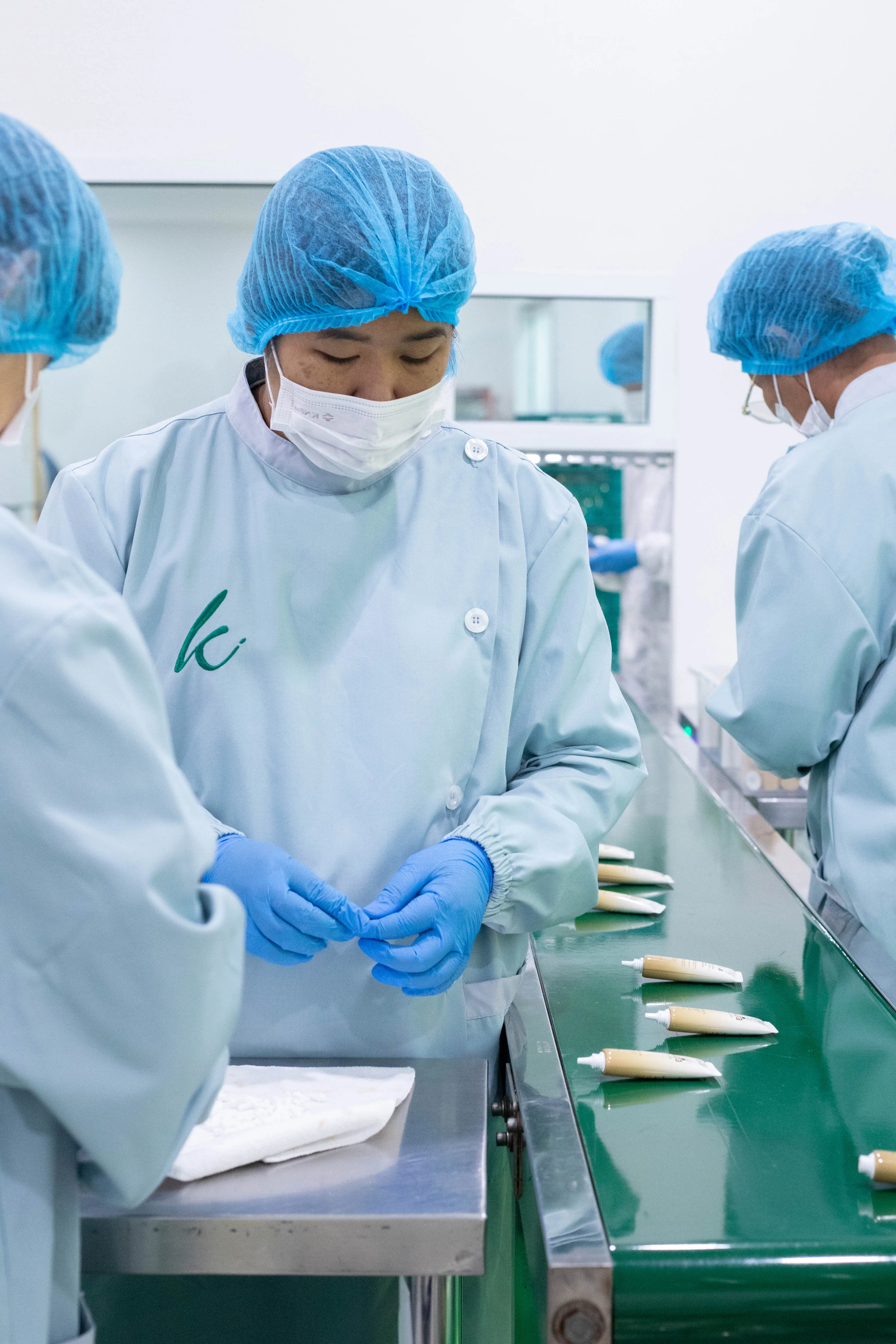 พนักงานตรวจเก็บรายละเอียดหลอดครีมหลังการบรรจุ